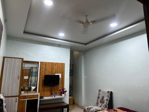 a living room with a ceiling fan and a tv at Hotel Priyanka in Raisen