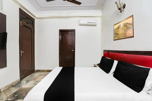- une chambre avec un lit doté d'une tête de lit rouge dans l'établissement Super Hotel O Paharganj Near Railway Station Formerly Chand Palace, à New Delhi