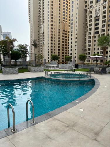 a large swimming pool in a city with tall buildings at LYO guest house Dubai marina BEDSPACE in Dubai