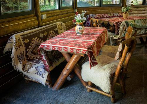 a table and chairs with a vase on top of it at HOTEL CARPAT INN in Azuga