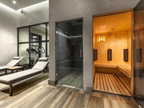 a room with a walk in shower and a glass door at Hotel Sadova in Gdańsk