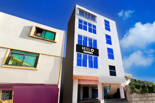 a tall white building with a sign on it at Super Hotel O Bhubaneshwar Near ITER College in Bhubaneshwar