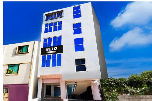 a tall white building with a sign on it at Super Hotel O Bhubaneshwar Near ITER College in Bhubaneshwar
