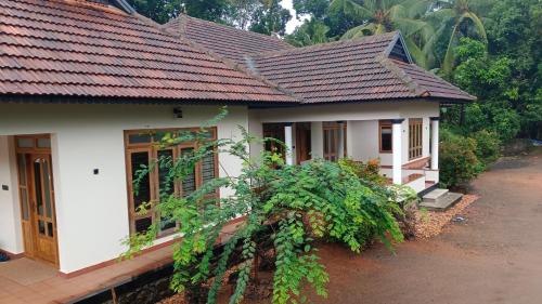 a house with white walls and red roof at Mountain View Villa Vacation Rental in Idukki