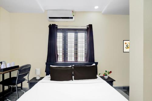 a bedroom with a white bed and a window at Super Collection O Kothapet Near Omini Hospital in Upal