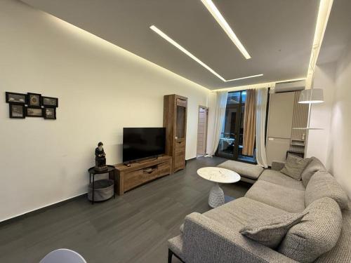 a living room with a couch and a flat screen tv at Stylish 2BR Apartment with Balcony by Republic Square - City Center I Стильные апартаменты с 2 спальнями и балконом у площади Республики-Центр Города in Yerevan