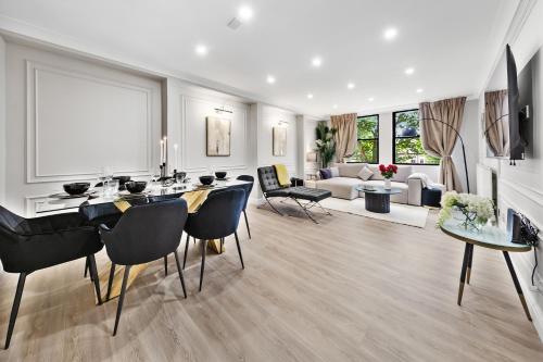 a living room with a table and chairs and a couch at The Queensborough Apartments by Hyde Park in London