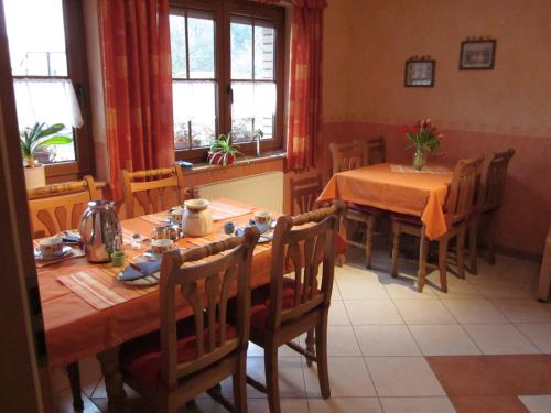 - une salle à manger avec 2 tables, des chaises et des fenêtres dans l'établissement Gästehaus Jüngling, à Kottenborn