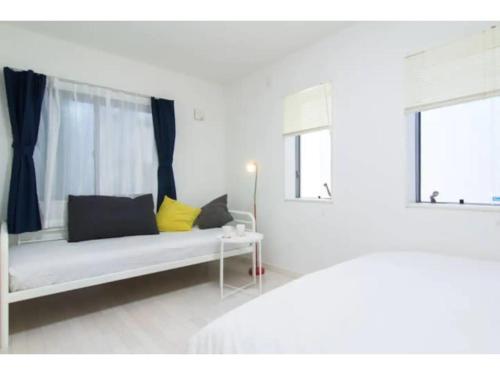 ein weißes Zimmer mit einem Bett und zwei Fenstern in der Unterkunft Hotel chen's house - Vacation STAY 42508v in Tokio