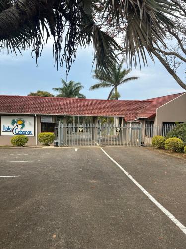 a building with a fence in a parking lot at BlueHive guesthouse Leisure in Port Edward