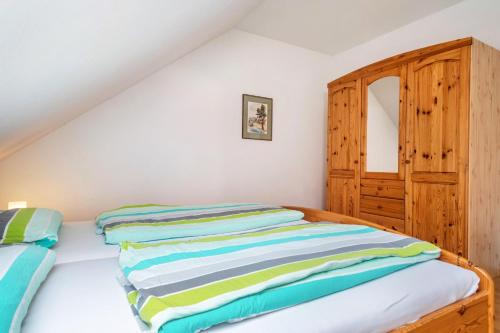 a bedroom with two beds and a wooden cabinet at Ferienhaus Am Kurpark in Bad Waldsee