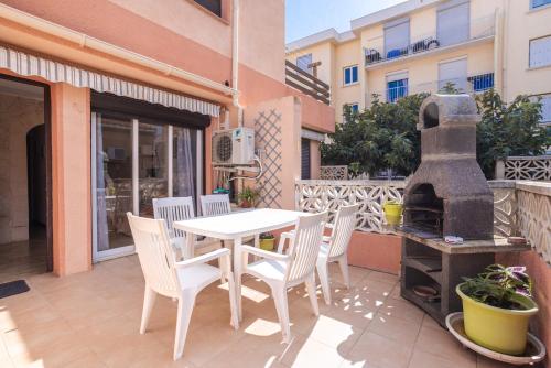 a patio with a table and chairs and a grill at Le Mieukerien - Réserve africaine in Port-la-Nouvelle