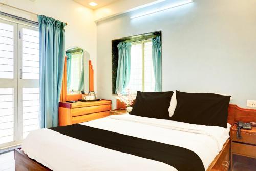 a bedroom with a large bed with blue curtains at Super Collection O Ubale Nagar in Pune