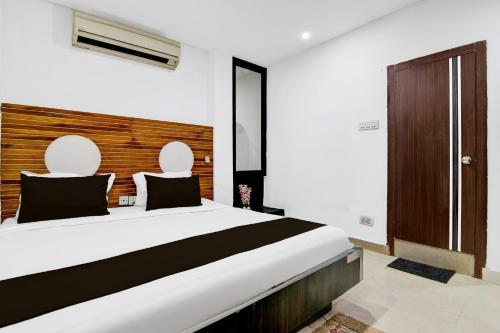 a bedroom with a large white bed with two chairs at Super Collection O Minto Park Formerly Hotel Gardenia in Ballygunge
