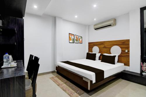 a bedroom with a bed and a desk in it at Super Collection O Minto Park Formerly Hotel Gardenia in Ballygunge