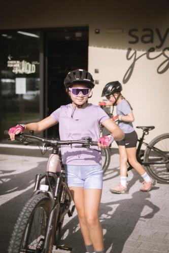 two women wearing helmets and holding a bike at Haunold Homes in San Candido