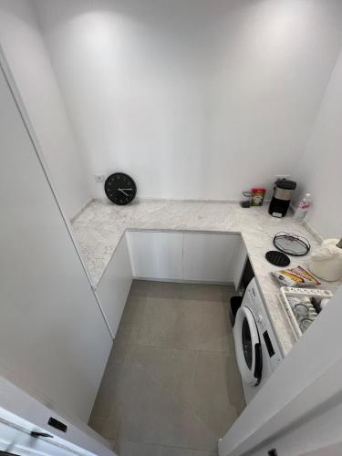 una cucina bianca con lavello e fornello di Villa Ryma a Ḩammām al Ghazzāz