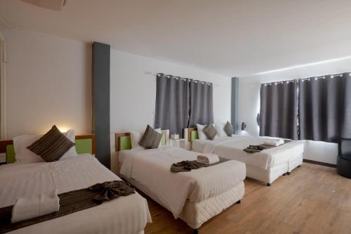 a hotel room with three beds and a couch at My Way Hua Hin Music Hotel SHA Extra Plus in Hua Hin