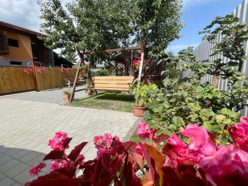 a park bench in a garden with pink flowers at One Floor under High Tatras in Malý Slavkov