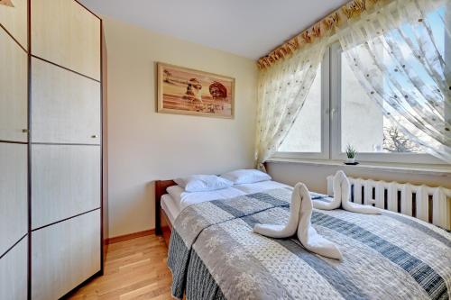 a bedroom with a bed with white shoes on it at Cozy Amber in Gdańsk