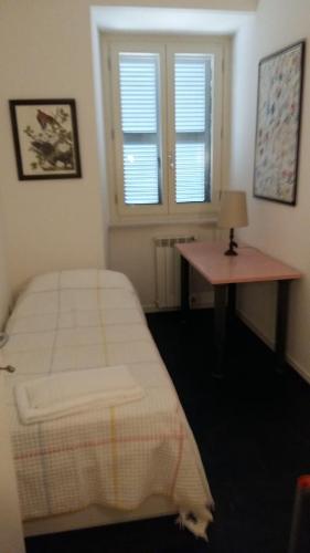 a bedroom with a bed and a desk and window at Il Conventino Appartamento in Osimo