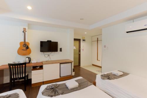 a bedroom with a desk and a guitar on the wall at My Way Hua Hin Music Hotel SHA Extra Plus in Hua Hin