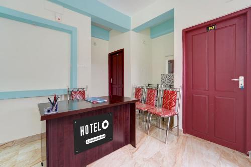 a hotel entrance with a red door and chairs at Super Hotel O Kazhakuttam Vadakkumbhagam in Trivandrum