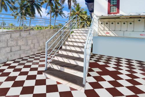 a staircase leading to a house with a checkered floor at Super Hotel O Kazhakuttam Vadakkumbhagam in Trivandrum
