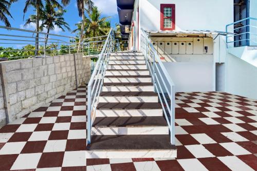 a staircase leading up to a house with a checkered floor at Super Hotel O Kazhakuttam Vadakkumbhagam in Trivandrum