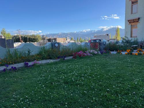 a yard with a garden with flowers in it at Mandalchan hotel in Leh