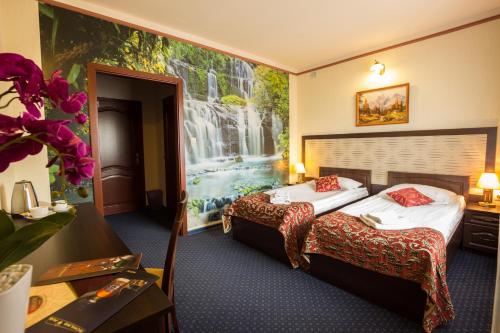 pokój hotelowy z 2 łóżkami i obrazem na ścianie w obiekcie Złote Arkady w mieście Częstochowa
