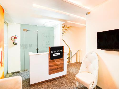 a waiting room with a tv and a chair at Super Townhouse Pitampura West Enclave in New Delhi