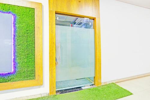 a glass door on a building with a green wall at Super Collection O Adajan Formerly Hotel Western Inn in Surat