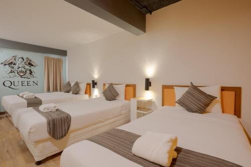 a room with three beds and a sign on the wall at My Way Hua Hin Music Hotel SHA Extra Plus in Hua Hin