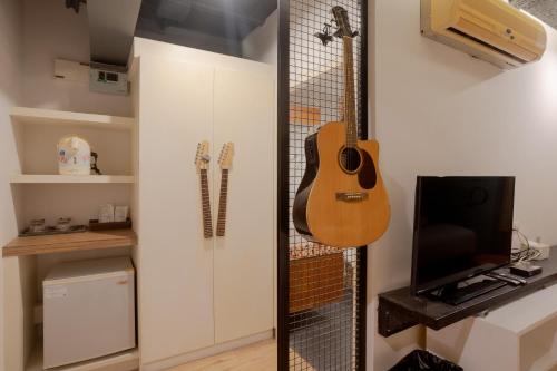 a guitar hanging on a wall in a room at My Way Hua Hin Music Hotel SHA Extra Plus in Hua Hin