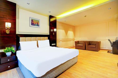 a bedroom with a large white bed in a room at Palette South Delhi Formerly Imperial Villa in New Delhi