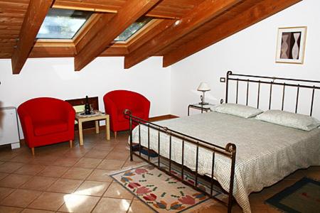 a bedroom with a bed and two red chairs at Residence Bizzoni in Terni