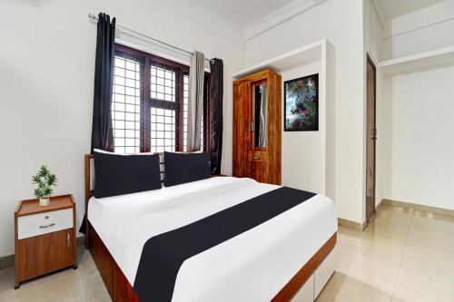 a bedroom with a large bed and a window at Super Hotel O West Hill near Mietra Hospital in Calicut
