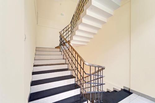 a staircase in a building with black and white at Super Hotel O West Hill near Mietra Hospital in Calicut