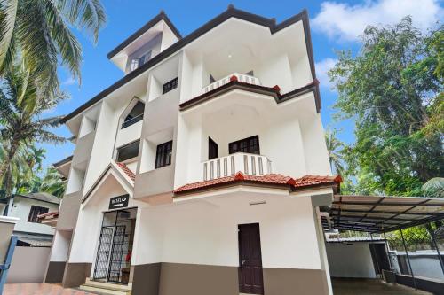 a large white building with a balcony at Super Hotel O West Hill near Mietra Hospital in Calicut