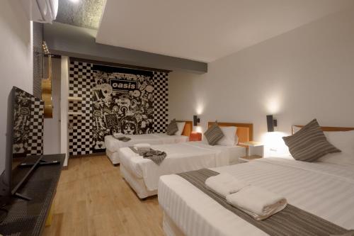 a hotel room with two beds and a tv at My Way Hua Hin Music Hotel SHA Extra Plus in Hua Hin