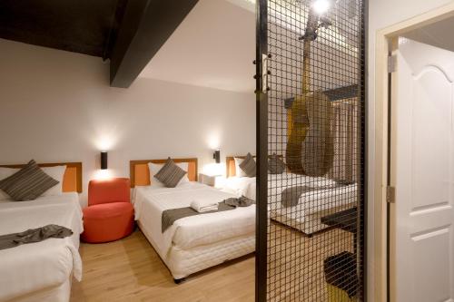 a hotel room with two beds and a bathroom at My Way Hua Hin Music Hotel SHA Extra Plus in Hua Hin