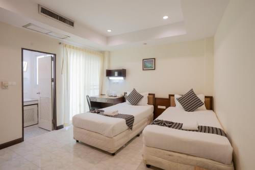 a hotel room with two beds and a chair at My Way Hua Hin Music Hotel SHA Extra Plus in Hua Hin