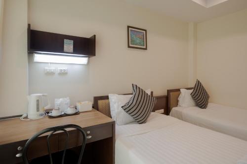 a hotel room with two beds and a desk with a chair at My Way Hua Hin Music Hotel SHA Extra Plus in Hua Hin