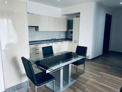 a kitchen with a glass table and two chairs at Henrietta's Residence, Cantonments in Accra