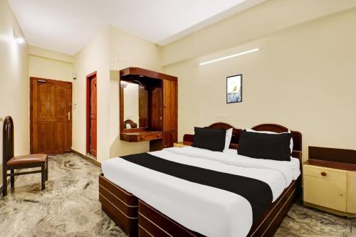 a bedroom with a large bed in a room at Super Hotel O East Nada in Guruvāyūr
