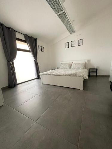 a bedroom with a bed and a large window at L&C hideaway in Sestu