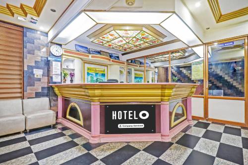 a hotel lobby with a bar and a checkered floor at Super Hotel O East Nada in Guruvāyūr