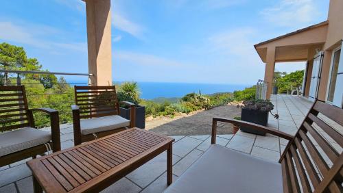 a balcony with benches and a view of the ocean at Sari- Vue mer- climatisation in Sari Solenzara