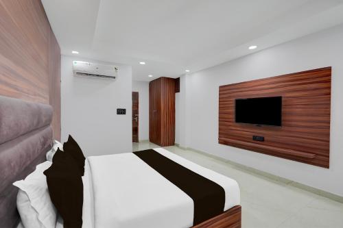 a bedroom with a bed and a flat screen tv at Super Collection O Sector 18 Metro station in Kalkaji Devi